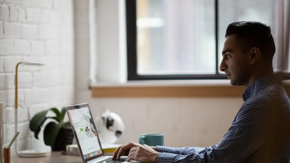 Software developer writing code on a laptop at a desk