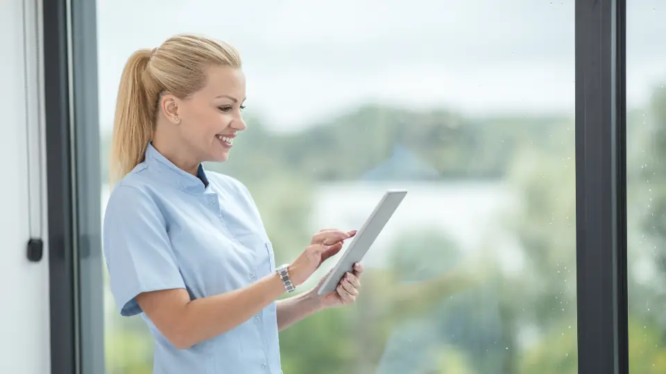 Nurse in uniform checking patient notes on a tablet