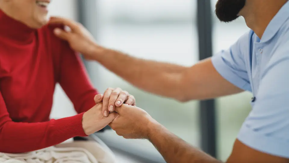 Therapist resting a supportive hand on a client's shoulder during a session