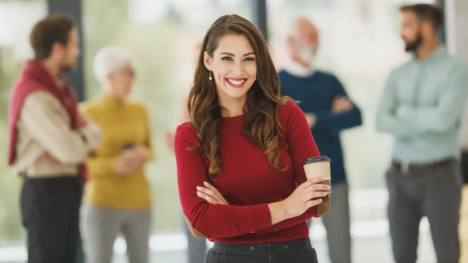 Skilled professional standing confidently in a modern office with colleagues