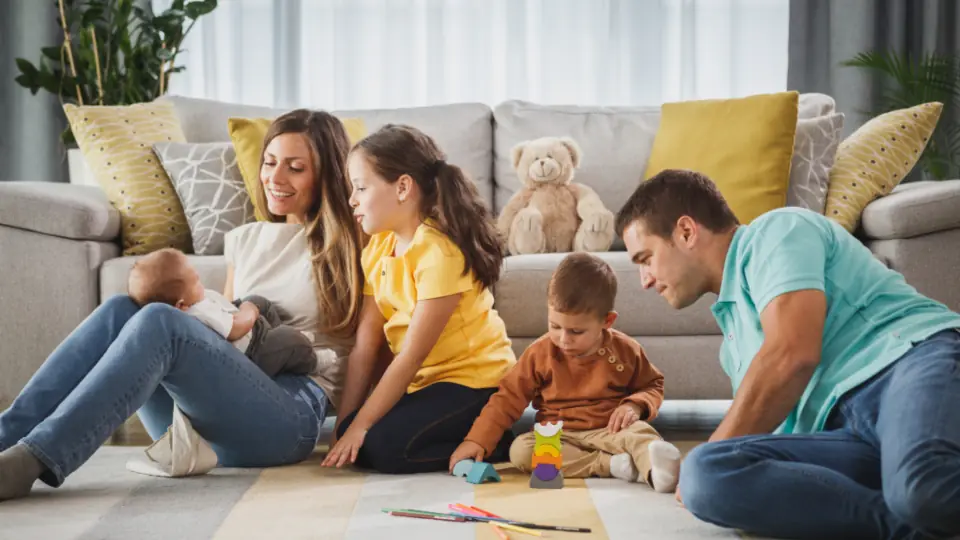 Family relaxing together on the floor of their living room at home