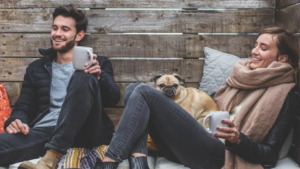Couple relaxing together at home with their dog