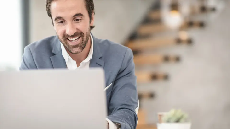 Smiling professional working on a laptop in a modern office