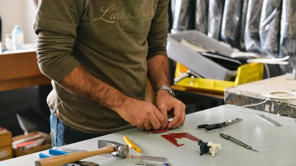 Worker using tools at a workbench in an industrial workshop