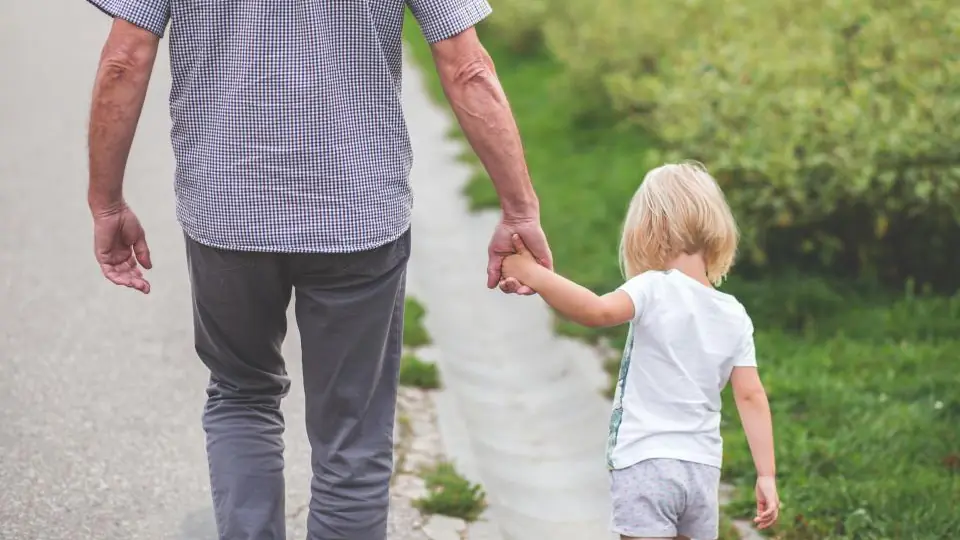 Grandparent walking hand in hand with a young grandchild